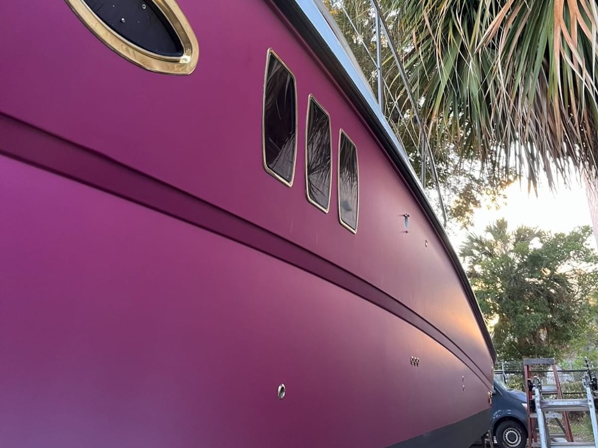 Close detail of a purple hull wrap around a brass porthole