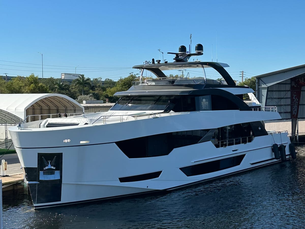 White and black motor yacht alongside a dock
